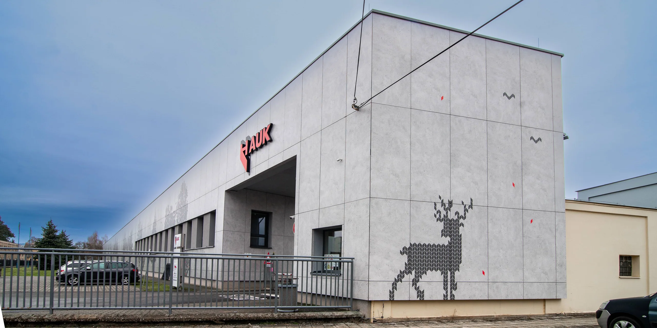 Světlá desková fasáda průmyslové budovy HAUK